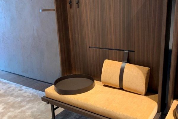 Schöne Idee: der stumme Diener als ganzer Raumteiler. Mit Sitzbank, Haken, Licht und Manschettentablett. Gesehen bei MINOTTI.